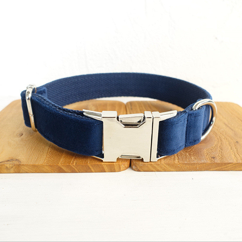 Navy blue velvet dog collar with silver metal buckle and D-ring on wooden display