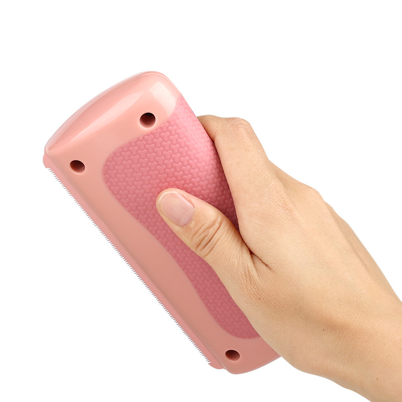 Hand holding a pink electronic device on a white background
