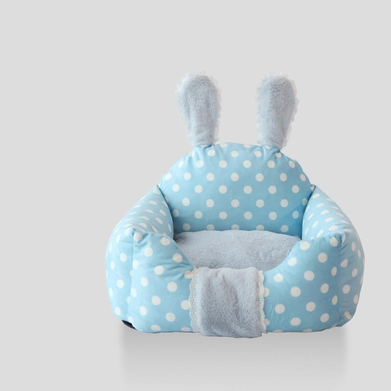 Blue polka dot baby seat with bunny ears on a white background