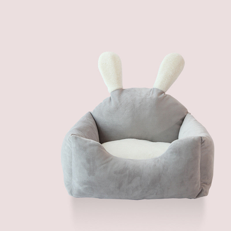 Gray pet bed with bunny ears on a pink background