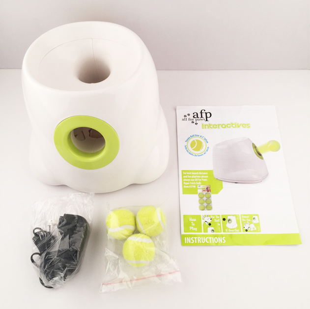 Pet toy set with a white and green cylindrical container, tennis balls, and an 'afp' branded package on a light background.