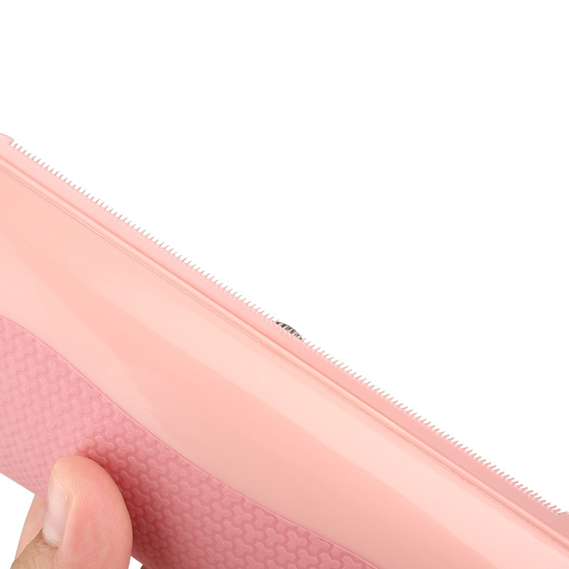 Close-up of a pink textured object with a hand holding it on a white background