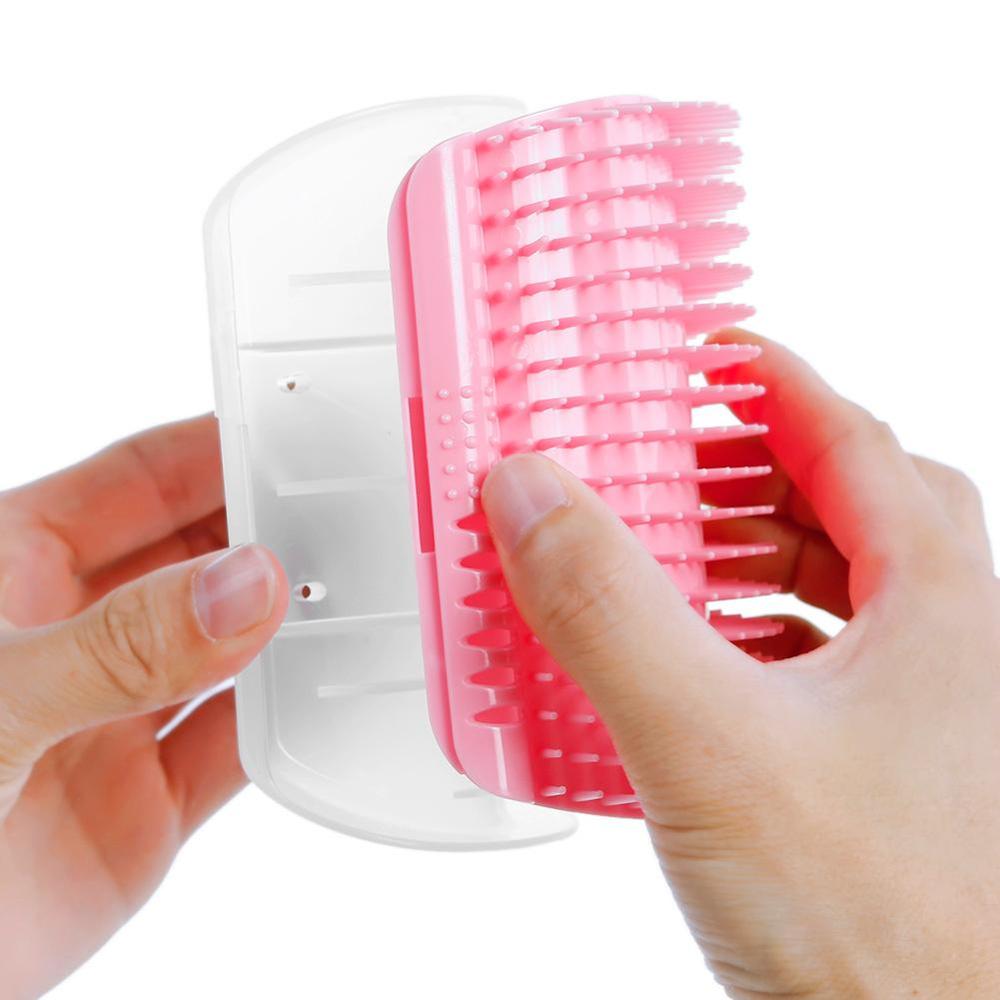 Pink grooming brush with clear handle held by a hand on a white background