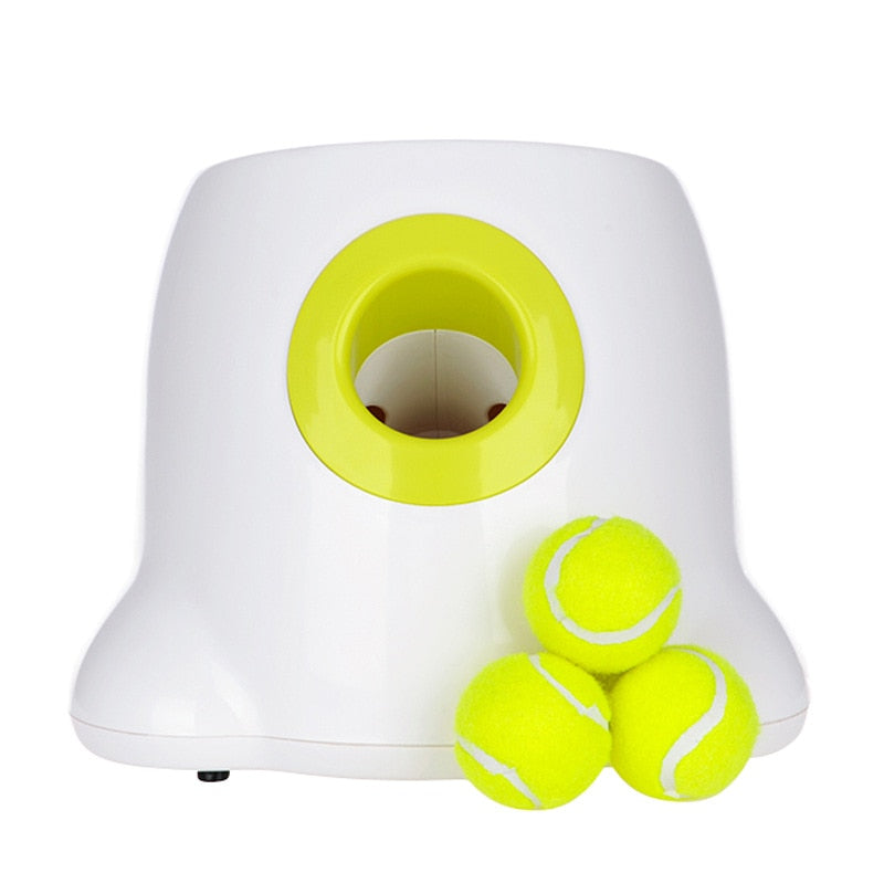 White and yellow tennis ball launcher with three tennis balls on a white background